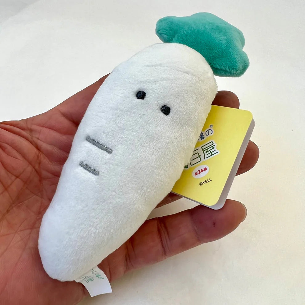 Hand holding a white plush radish with green top Fruit or Veggie Charm for backpacks or bags soft toy accessory.