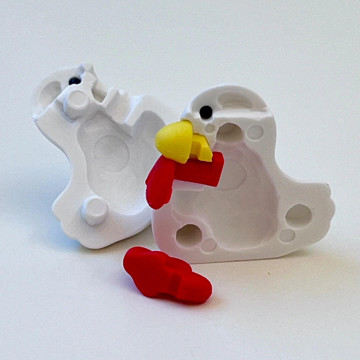 Japanese Eraser Chicken & Friends showing pieces of a colorful red and yellow chicken eraser puzzle on white mold.