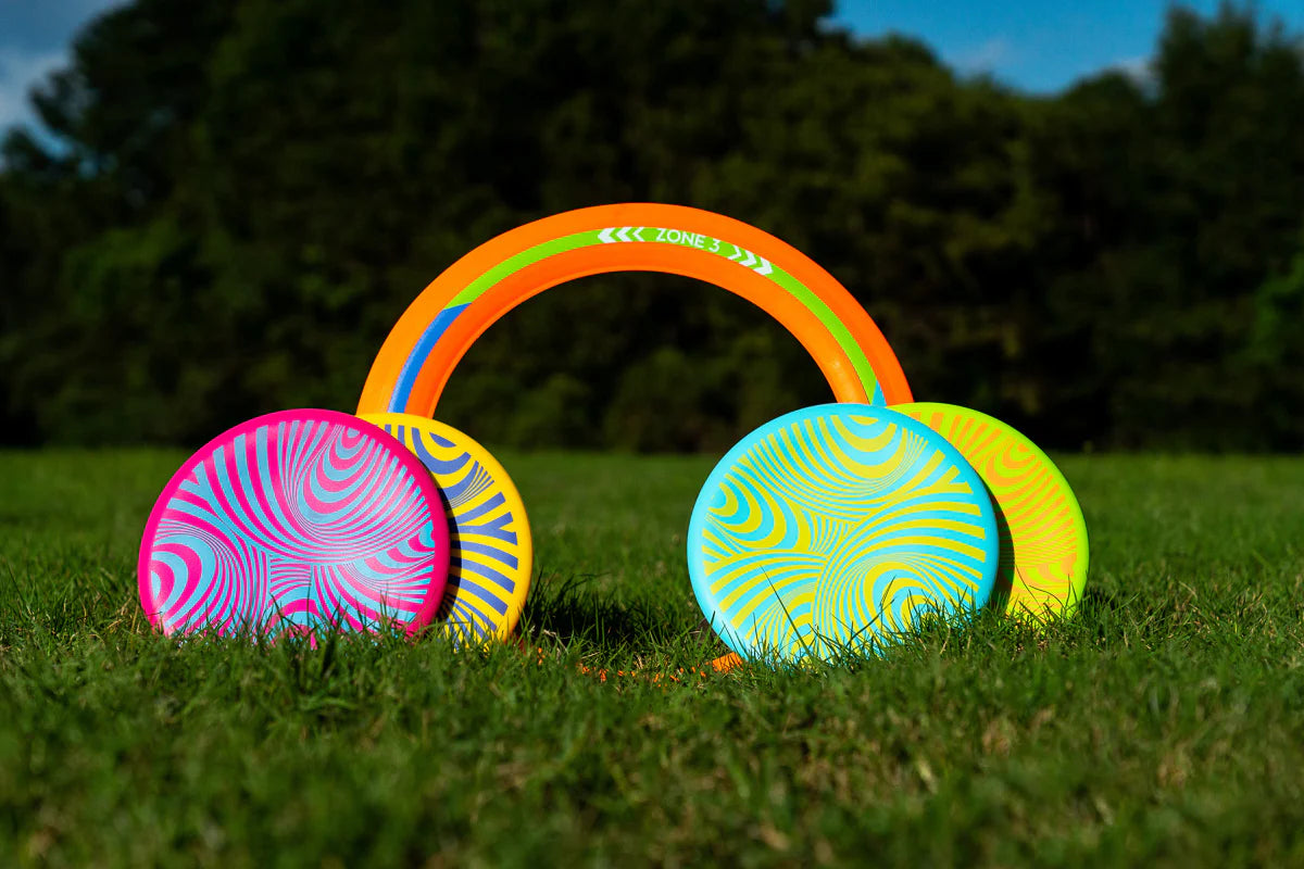 Waboba Backnine game set with flying target ring and four colorful silicone Wingman discs on grass outdoors.
