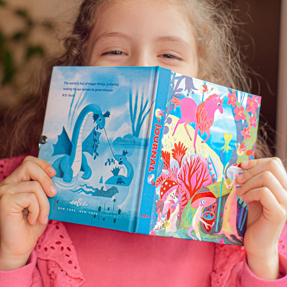 A child holding the Magical Creatures Diary featuring whimsical unicorn and dragon foil-stamped illustrations and vibrant colors.