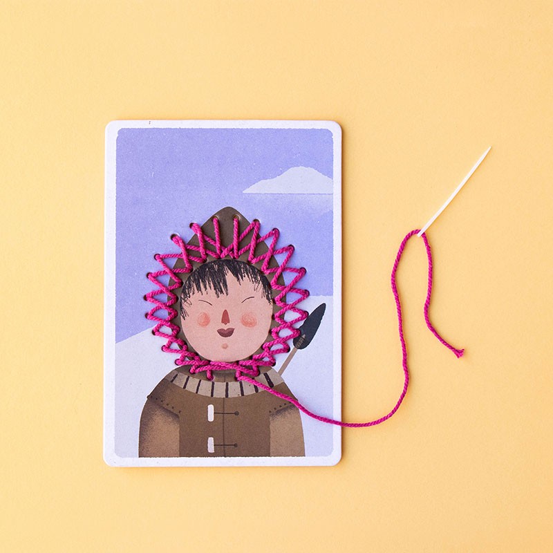 ZigZag Lacing embroidery kit showing pink wool threaded through a needle and illustrated cardboard template for sewing practice.