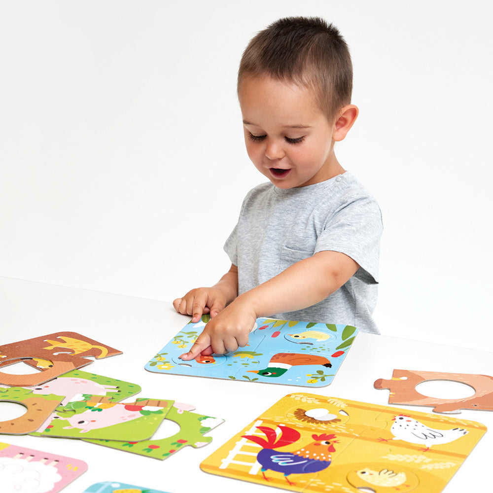 Young child playing with colorful farm animal pieces in the Match the Farm Animals Puzzle educational set.