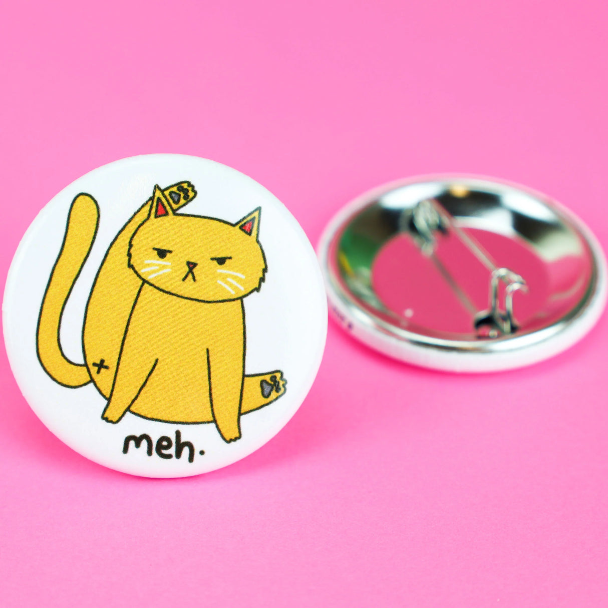 Meh Kitty Cat Button showing a yellow cat grooming with an unimpressed expression on white background pin back button.