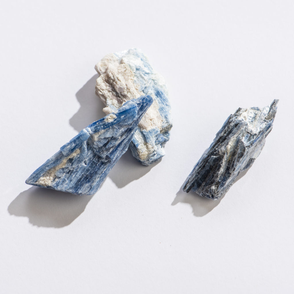 Rock | Rough Blue Kyanite showing natural textured surfaces with blue and white mineral layers on a white background