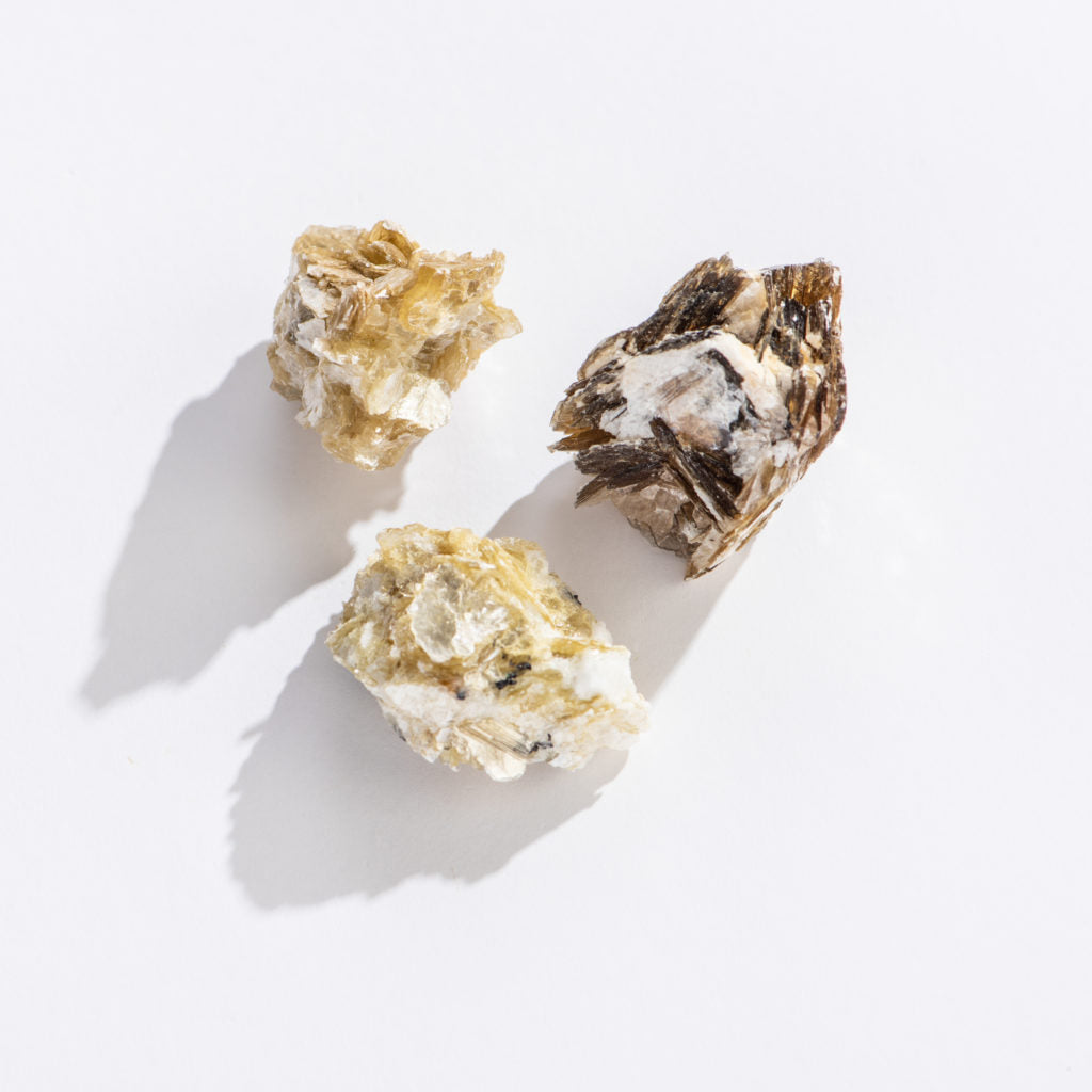 Rock Natural Star Mica showing three distinct shimmering mineral pieces on a white background.