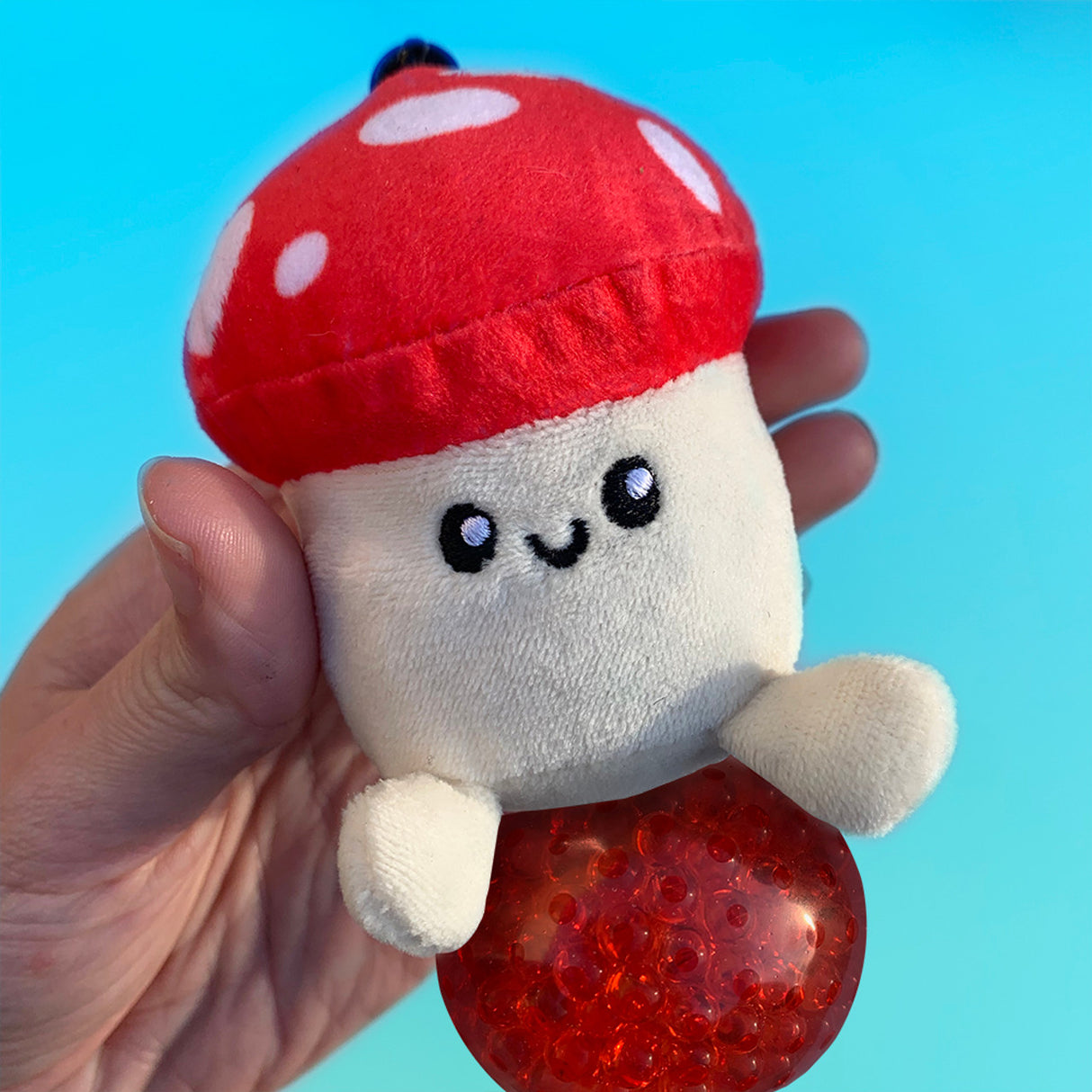 Beadie Buddies 90s Keychain soft plush mushroom with pop bead sensory bubble held in hand against blue background