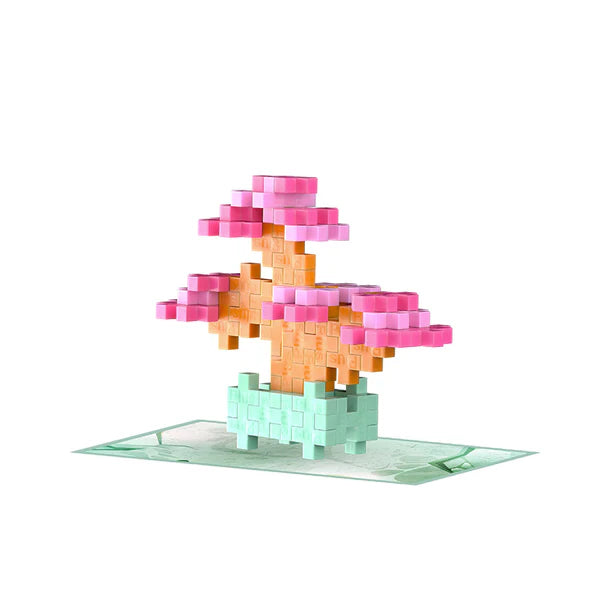 Plus Plus Playful Plant Packet with a pink and peach bonsai build on a themed green mat for creative play.