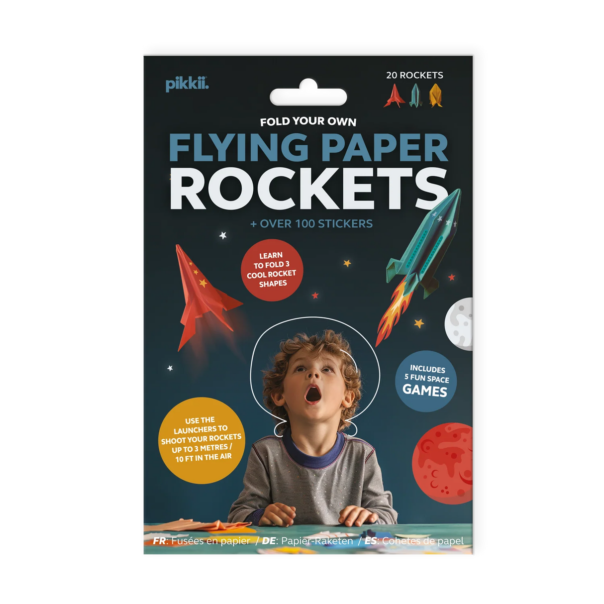 Child excitedly playing with colorful flying paper rockets and space-themed stickers kit packaging