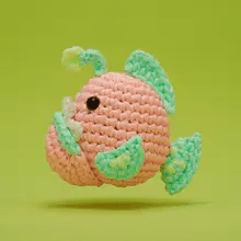 Handcrafted crochet angler fish with glow-in-the-dark yarn and adorable detailed stitches on green background
