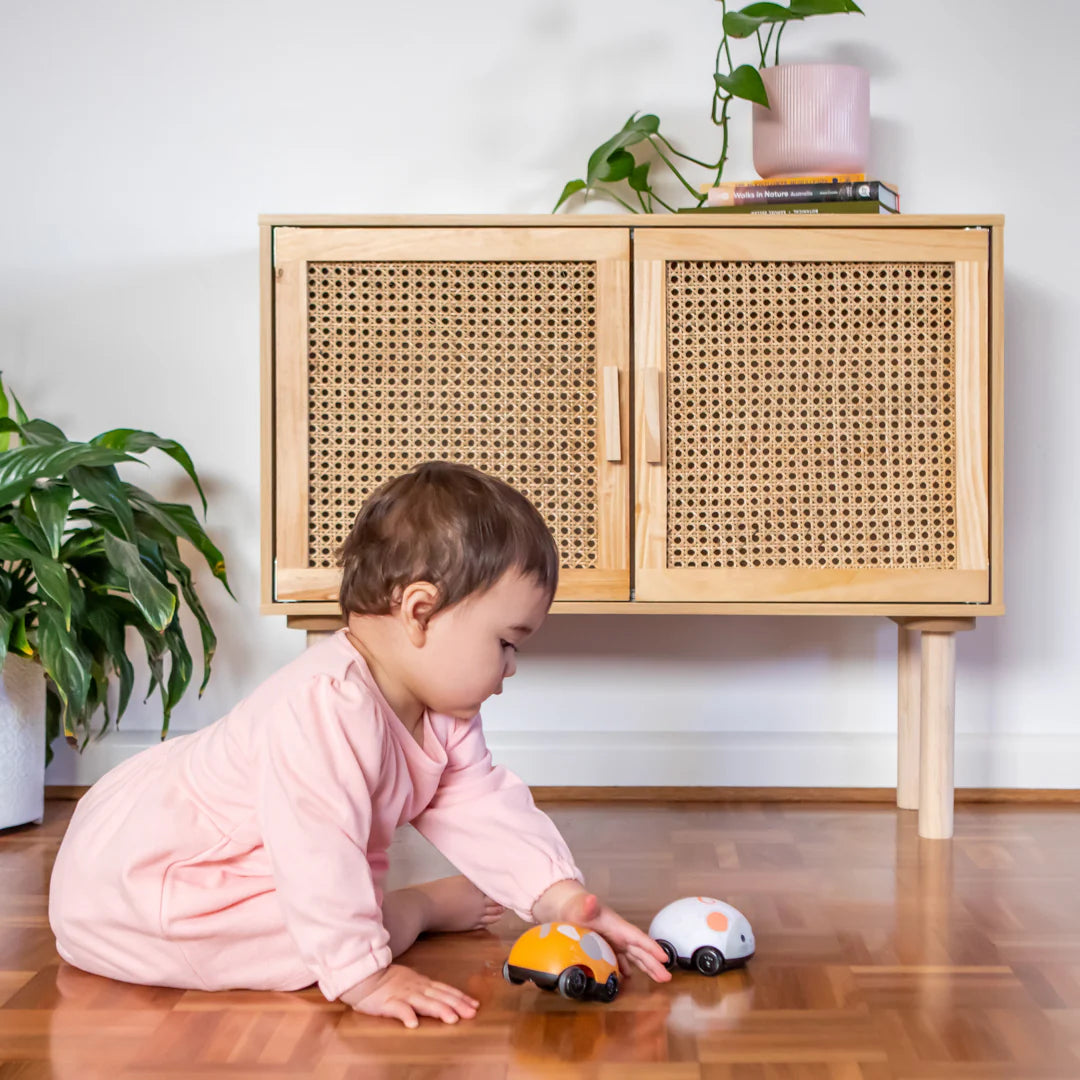 Baby playing with Cat & Mouse Pullbacks toys, pushing and pulling the compact animal figures on the wooden floor.