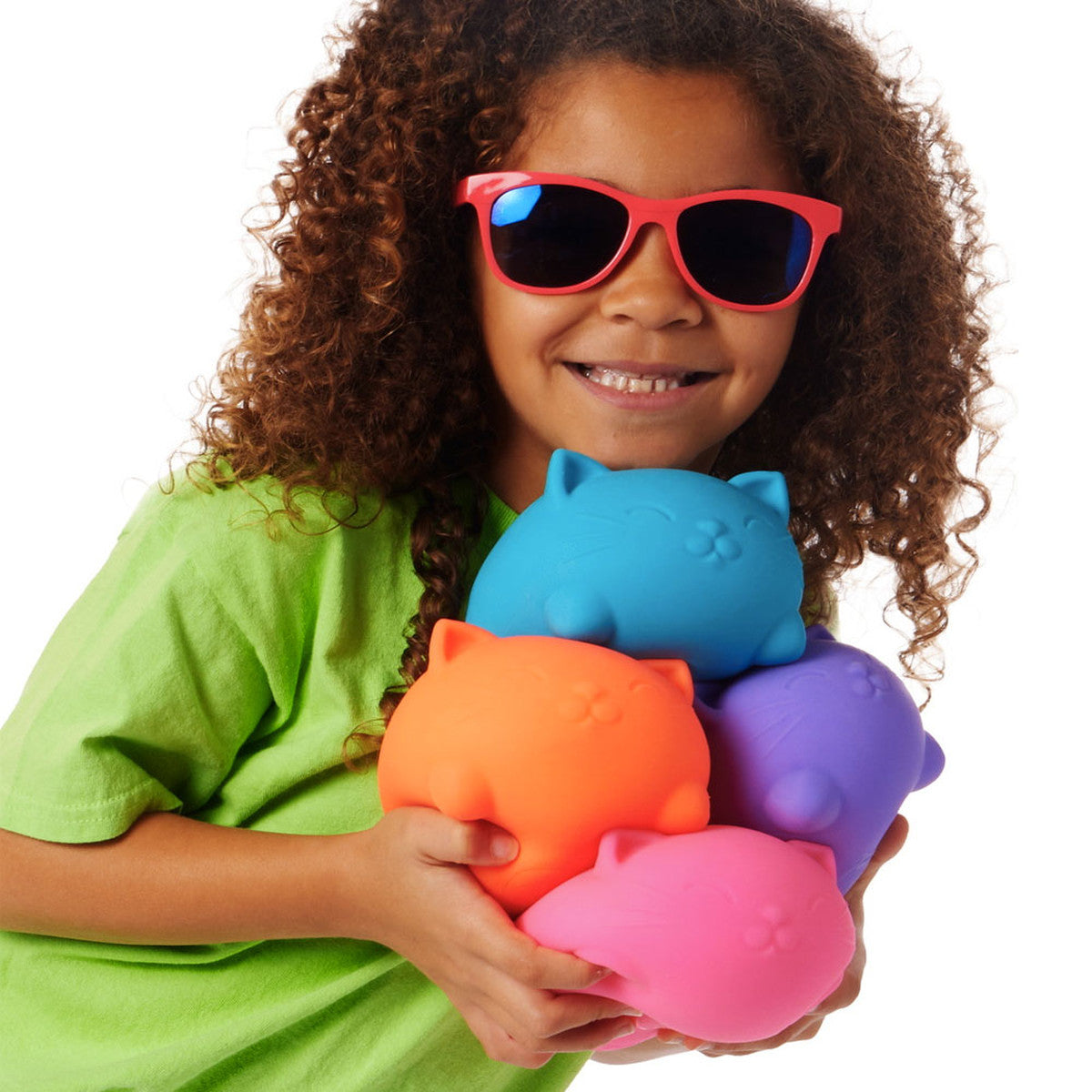 Child wearing red sunglasses holding colorful NeeDoh Super Cool Cat stress toys in blue, orange, purple, and pink.