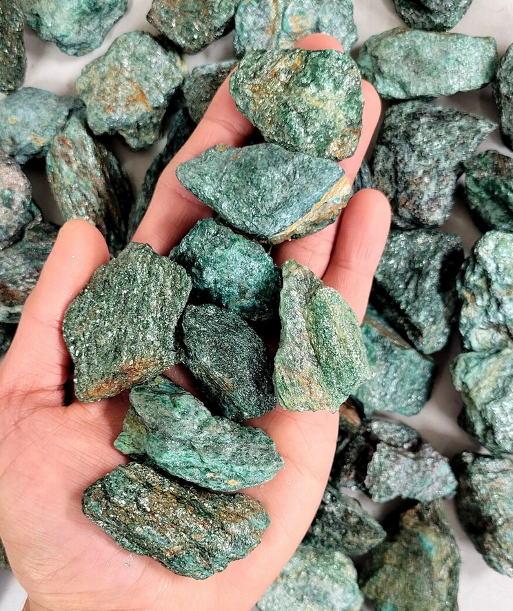 Rock | Rough Fuchsite natural green rough stones held in hand showcasing texture and color variety.