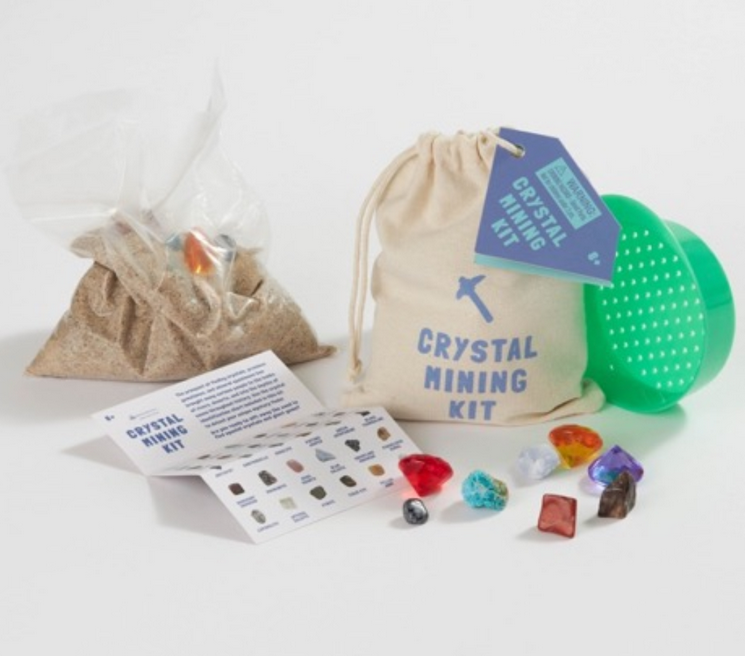 Crystal Mining Kit with genuine crystals, colorful acrylic gems, plastic sifter, sand, instruction guide, and cotton drawstring bag.