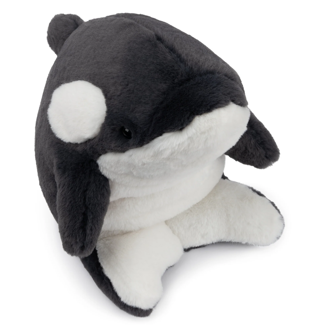 Snuffles Orca Flynn plush toy in black and white with a soft, huggable crescent-moon shape sitting upright.