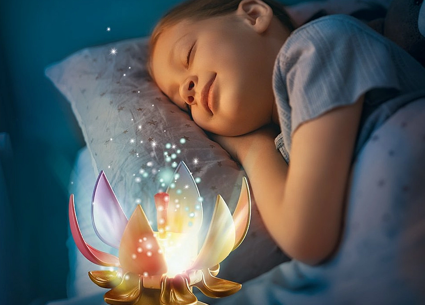 Princess Magic | Rainbow Castle in the Clouds glowing rainbow flower nightlight beside sleeping child in bed.