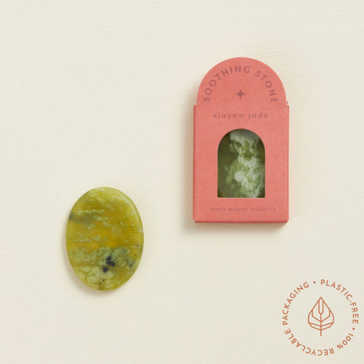 Soothing Stone | Xiuyan Jade oval matte stone with soft green patterns next to pink eco-friendly box packaging.
