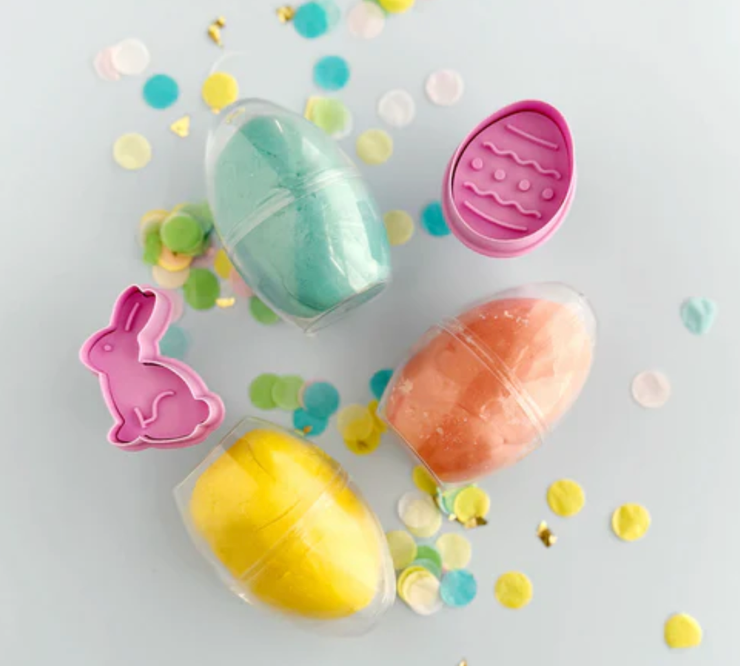 KidDough Easter Egg Play Tube with three colorful dough eggs and two spring plunger cutters on confetti background