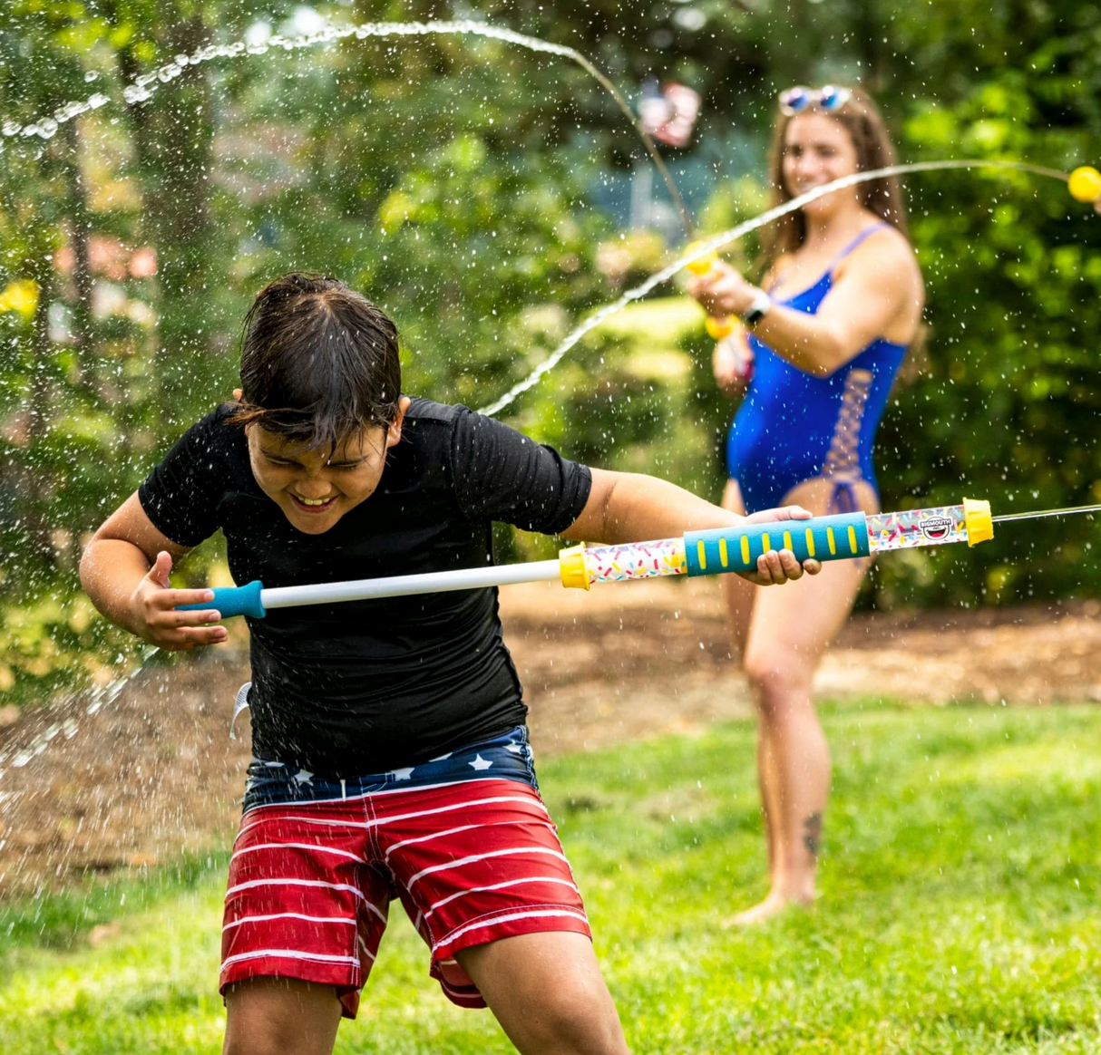 Child playing outside with a Water Cannon | Blue spraying water in a backyard water fight on a sunny day.