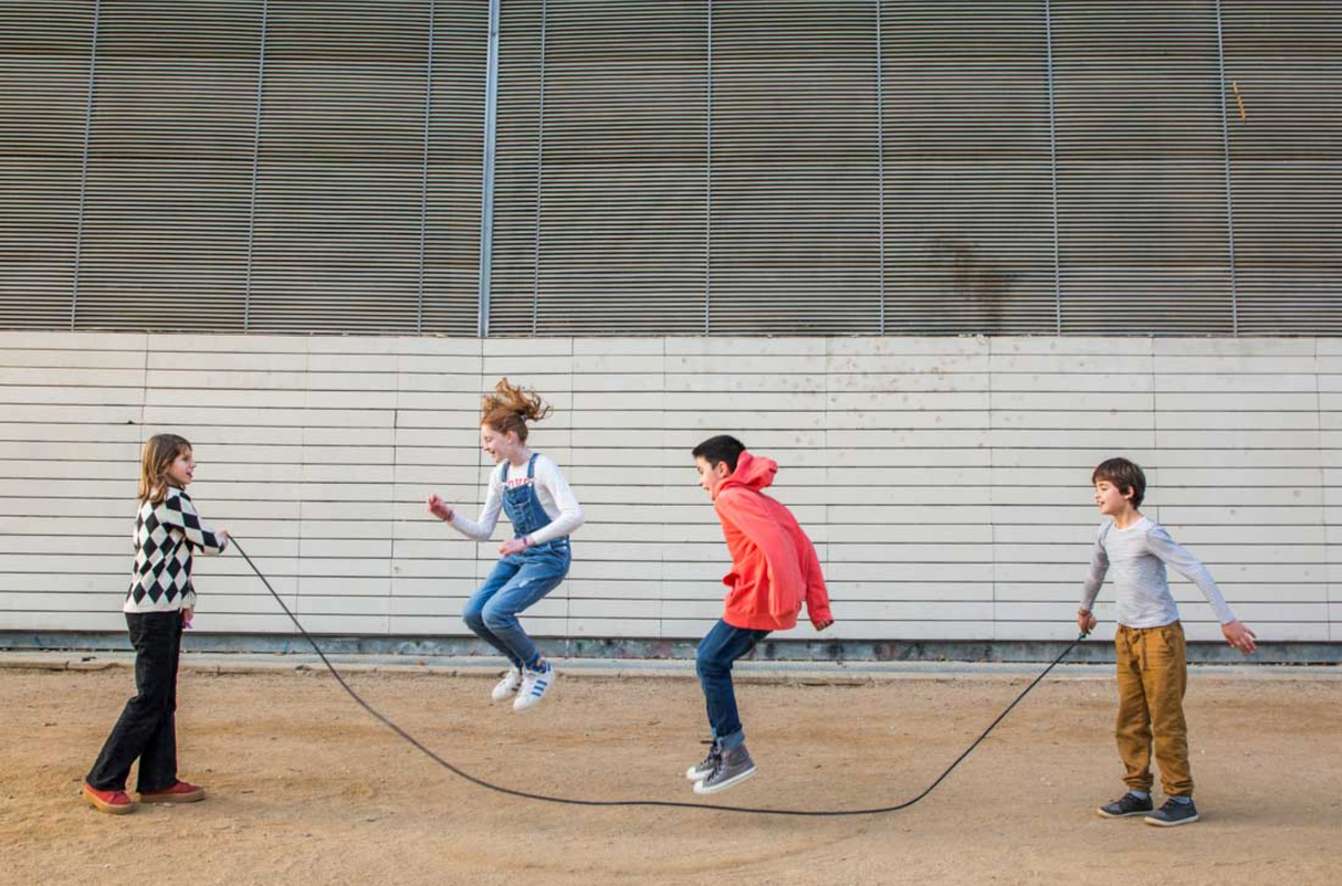 Jump Rope | Playground Coral & Mint used by children playing outdoors, featuring long cotton rope and wooden handles.