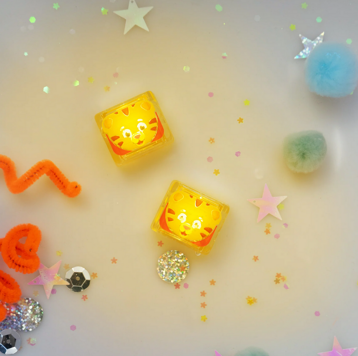 Glo Pals Daniel Tiger's Neighborhood light-up cubes glowing surrounded by colorful stars and pom-poms.