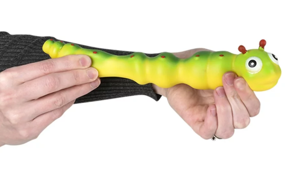 Hands stretching a green and yellow Stretchy Sand Caterpillar toy with a smooth silicone exterior.