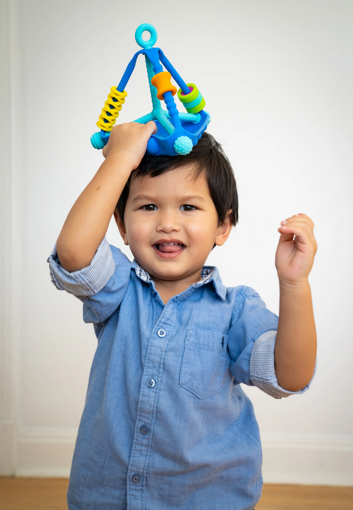 Toddler playing with the colorful Wigloo Activity Toy featuring silicone bubbles and spinning rings.