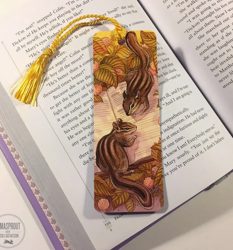 Bookmark | Chipmunk featuring two chipmunks exploring a book beneath autumn leaves with a golden tassel.