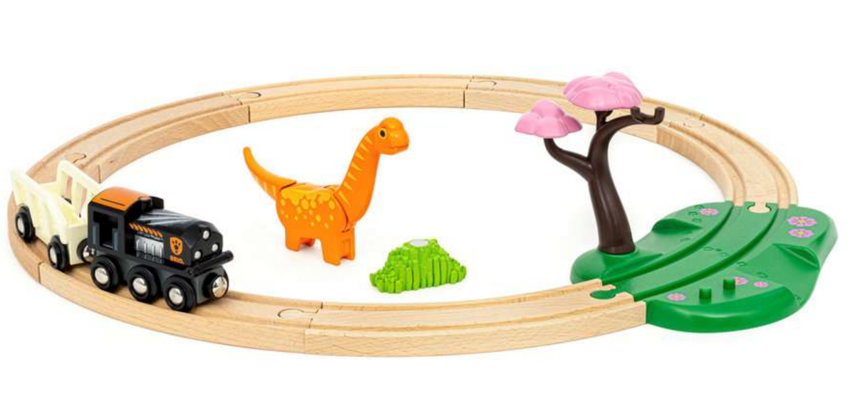 Dinosaur Circle Set with wooden train track, dinosaur figure, engine, wagon, grassy crossing, and tree play accessories.