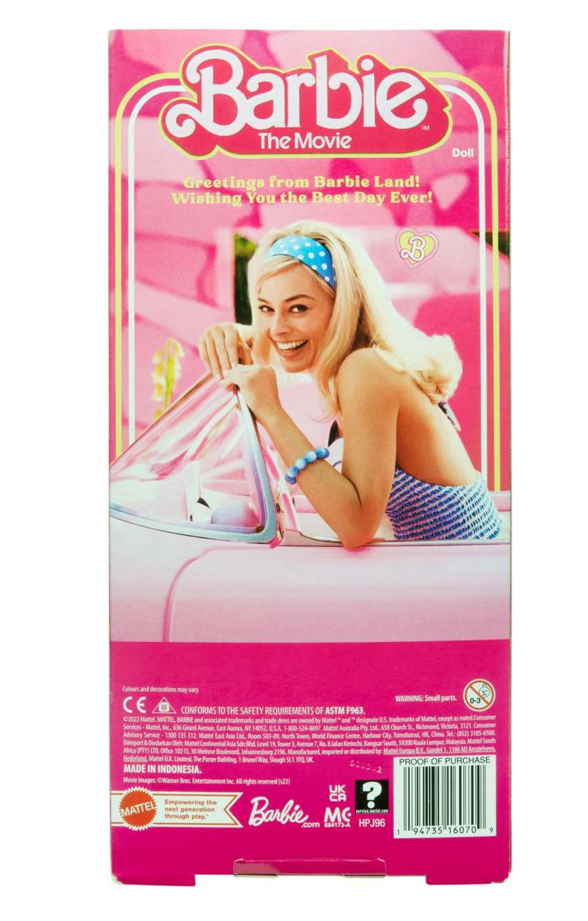 Barbie The Movie packaging featuring cheerful Barbie in a blue headband and striped outfit in a pink car.