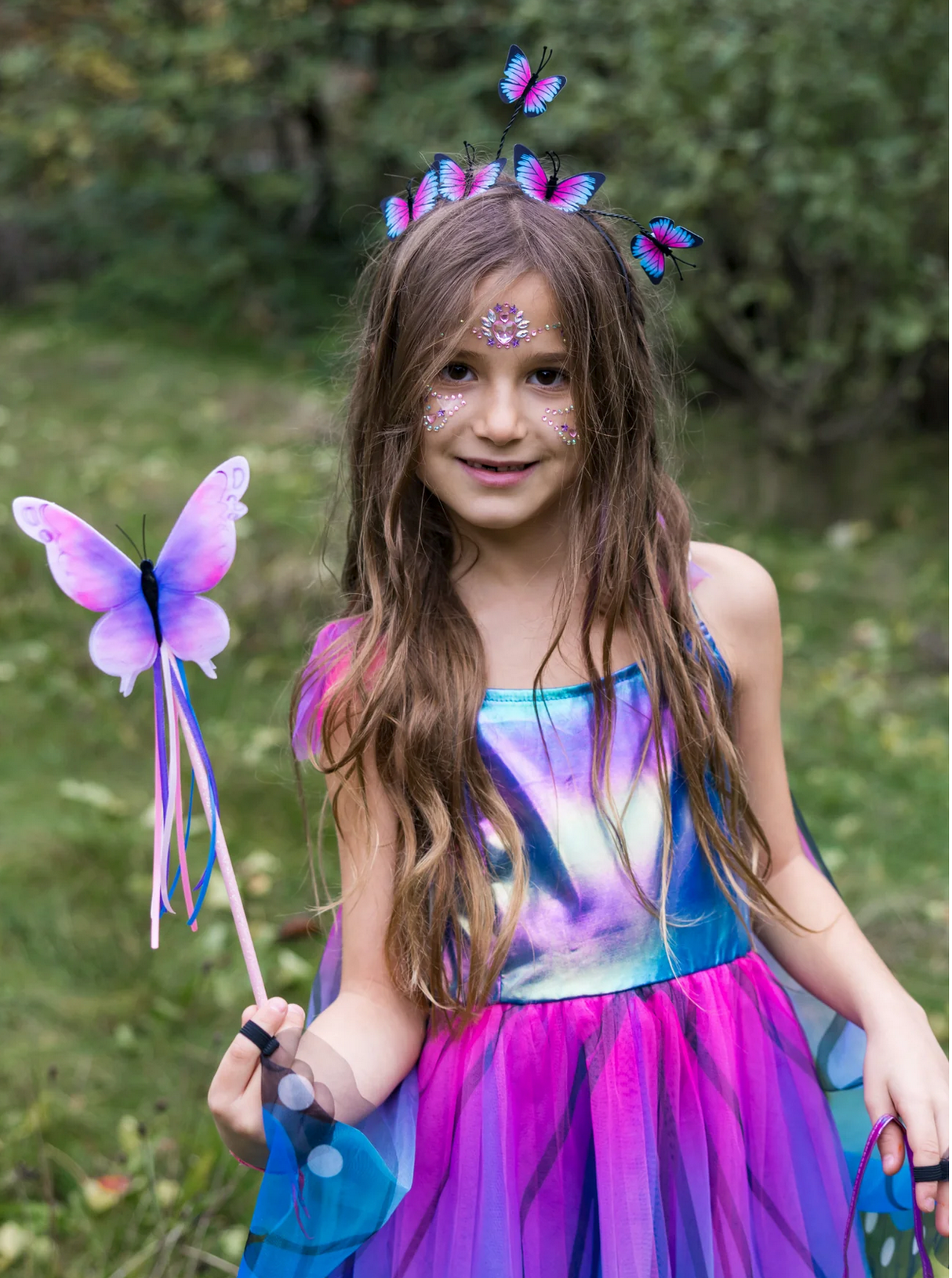 Young girl in colorful dress holding the Float Like A Butterfly Wand with a pink and purple butterfly design.