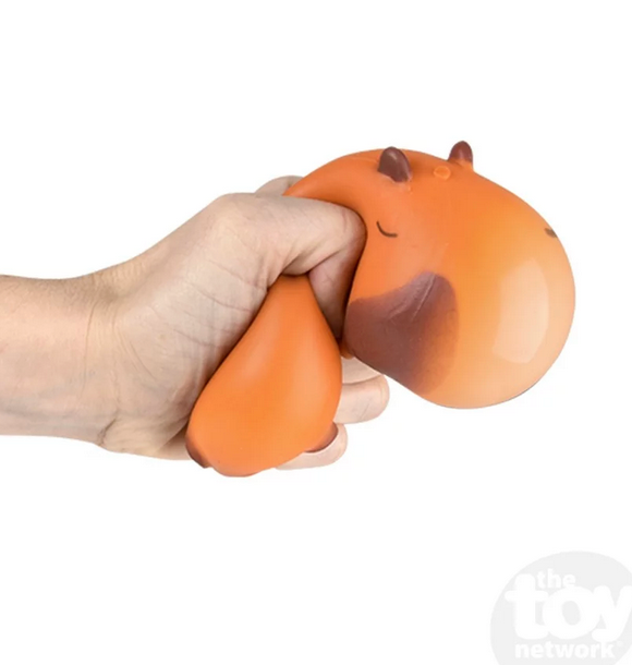 Hand squeezing an orange Squish & Stretch Capybara fidget toy for stress relief and sensory play.
