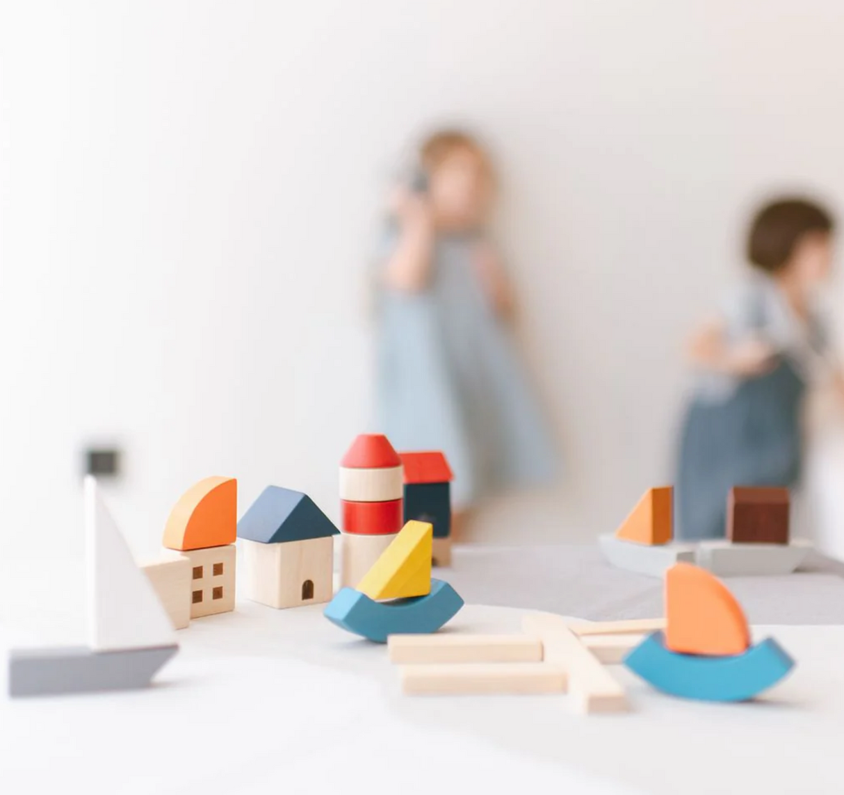 Marina Blocks wooden toy set with colorful sailboats, lighthouse, docks, and buildings for imaginative play.