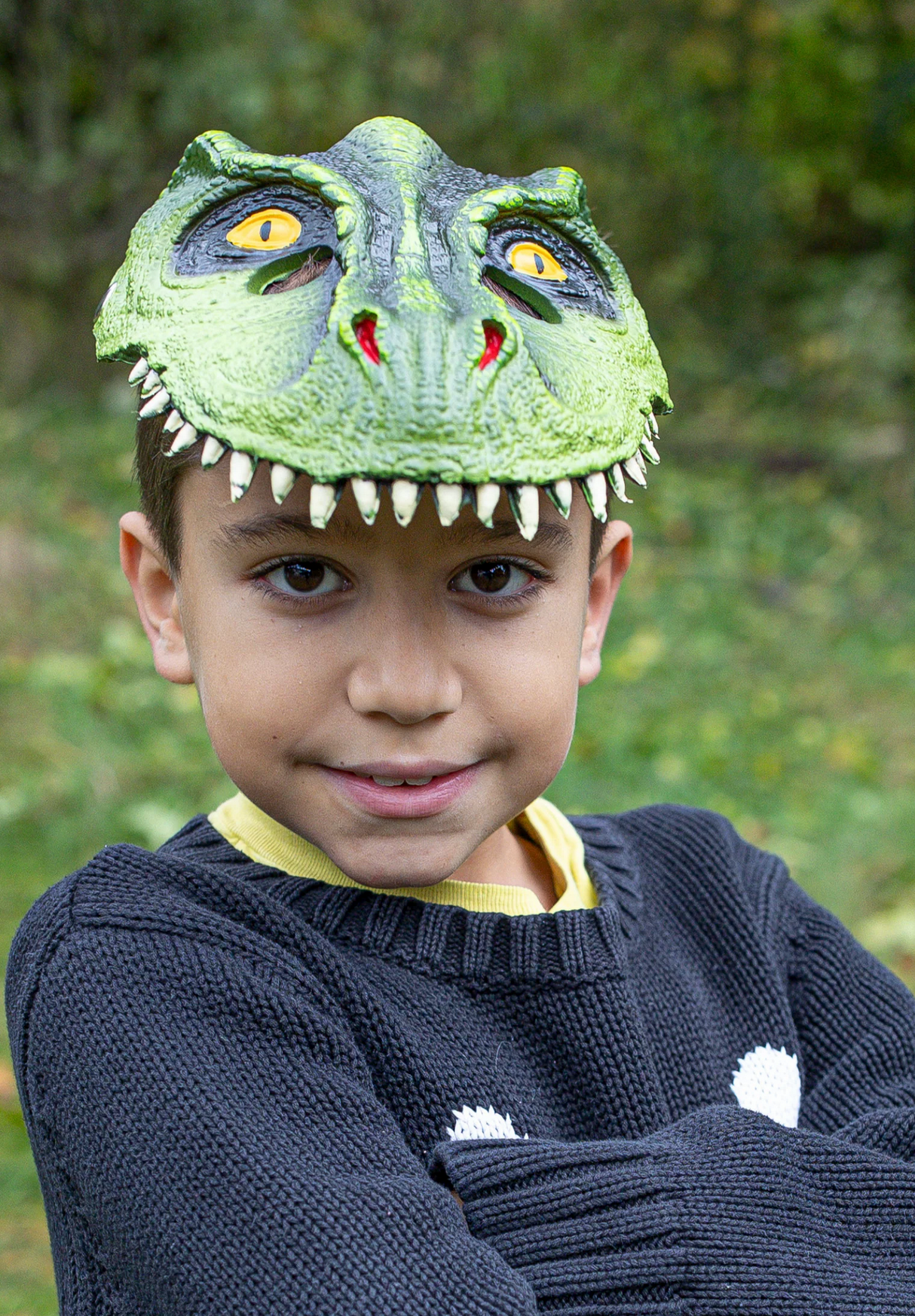 Boy wearing a vibrant green T-Rex Dino Mask made of durable rubberized material for imaginative play.