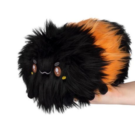 Soft and fluffy Wooly Caterpillar Mini plush with black and orange segments, held in hand for size reference.
