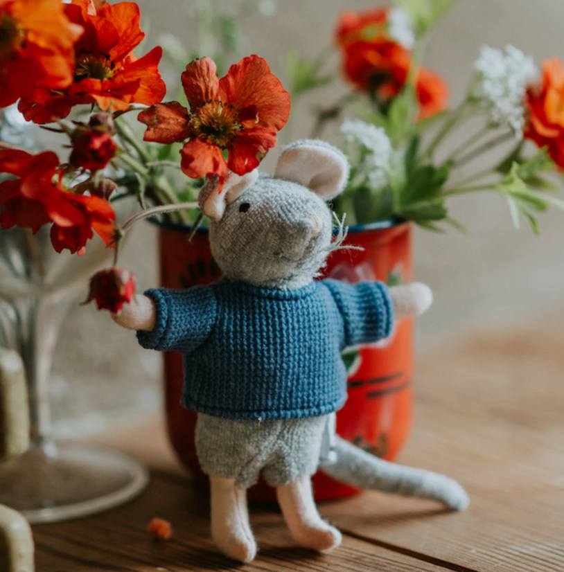 Sam & Julia | Sam plush mouse wearing blue sweater standing on table with orange flowers in background