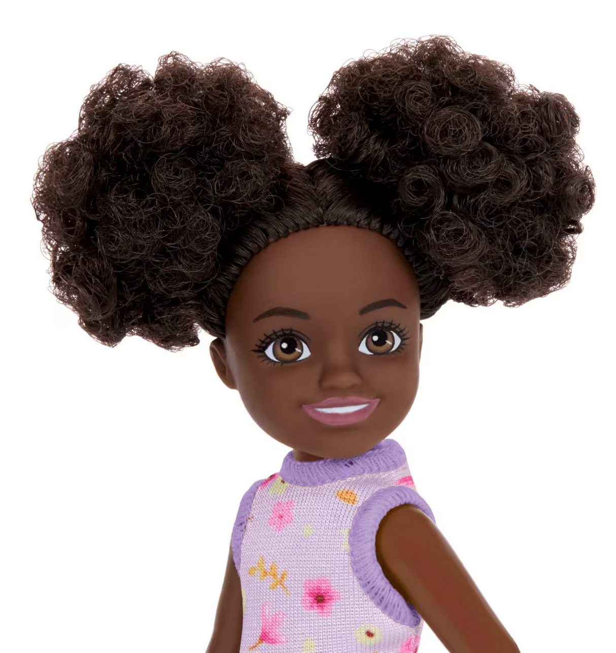 Barbie Chelsea #96 doll with curly hair in space buns wearing a purple floral knit dress and pink star shoes.