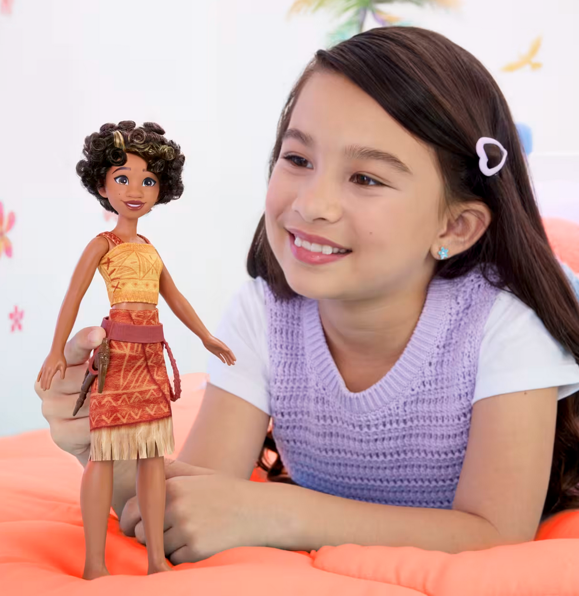 Girl playing with Disney Moana 2 Loto doll featuring articulated limbs and travel outfit with toolbelt and adze.