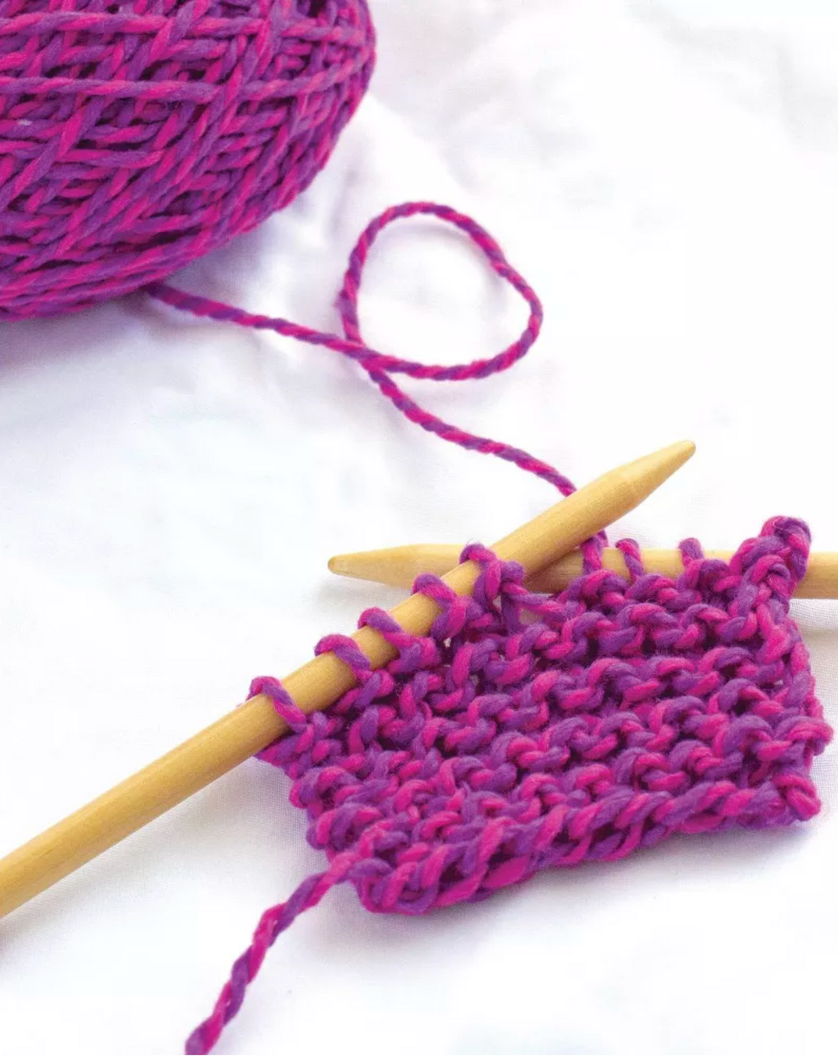 Discover Knitting Scarf Kit | Pink showing pink wool yarn and wooden needles knitting a garter stitch piece.