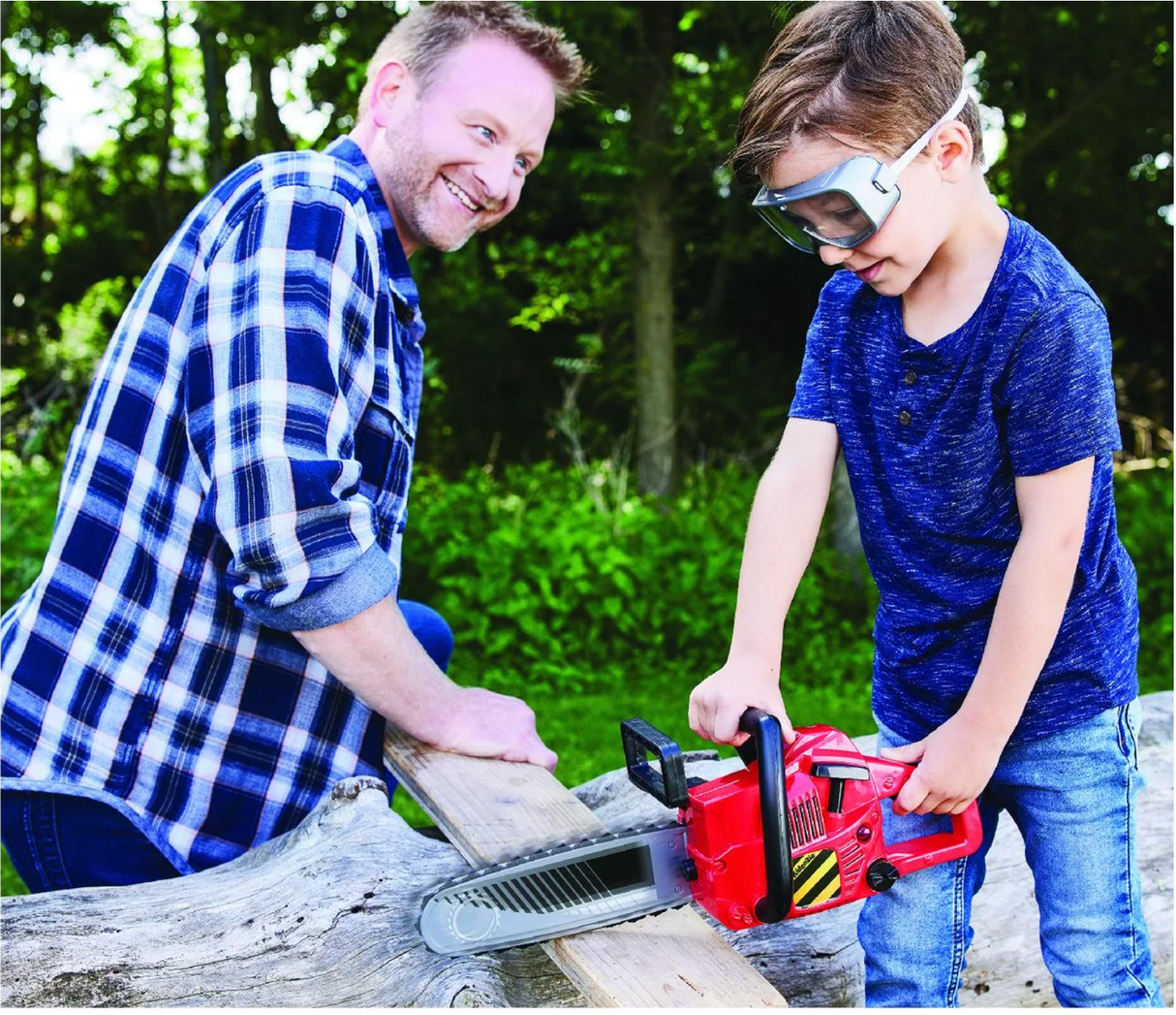 Child wearing goggles uses the Power Chainsaw toy outdoors while an adult watches, enjoying pretend play time together.