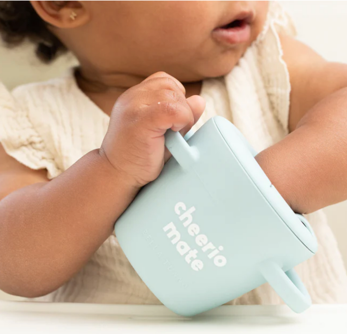 Baby using Happy Snacker | Cheerio Mate silicone snack cup with easy-grip handles and mess-proof lid.