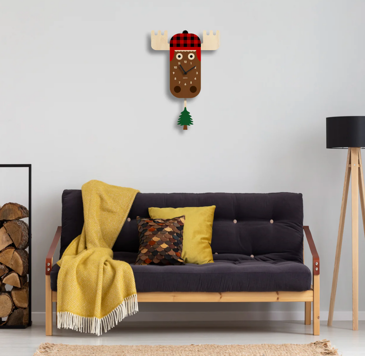 Wood Pendulum Clock | Moose with cozy flannel hat and swinging pine tree pendulum on white wall above sofa.
