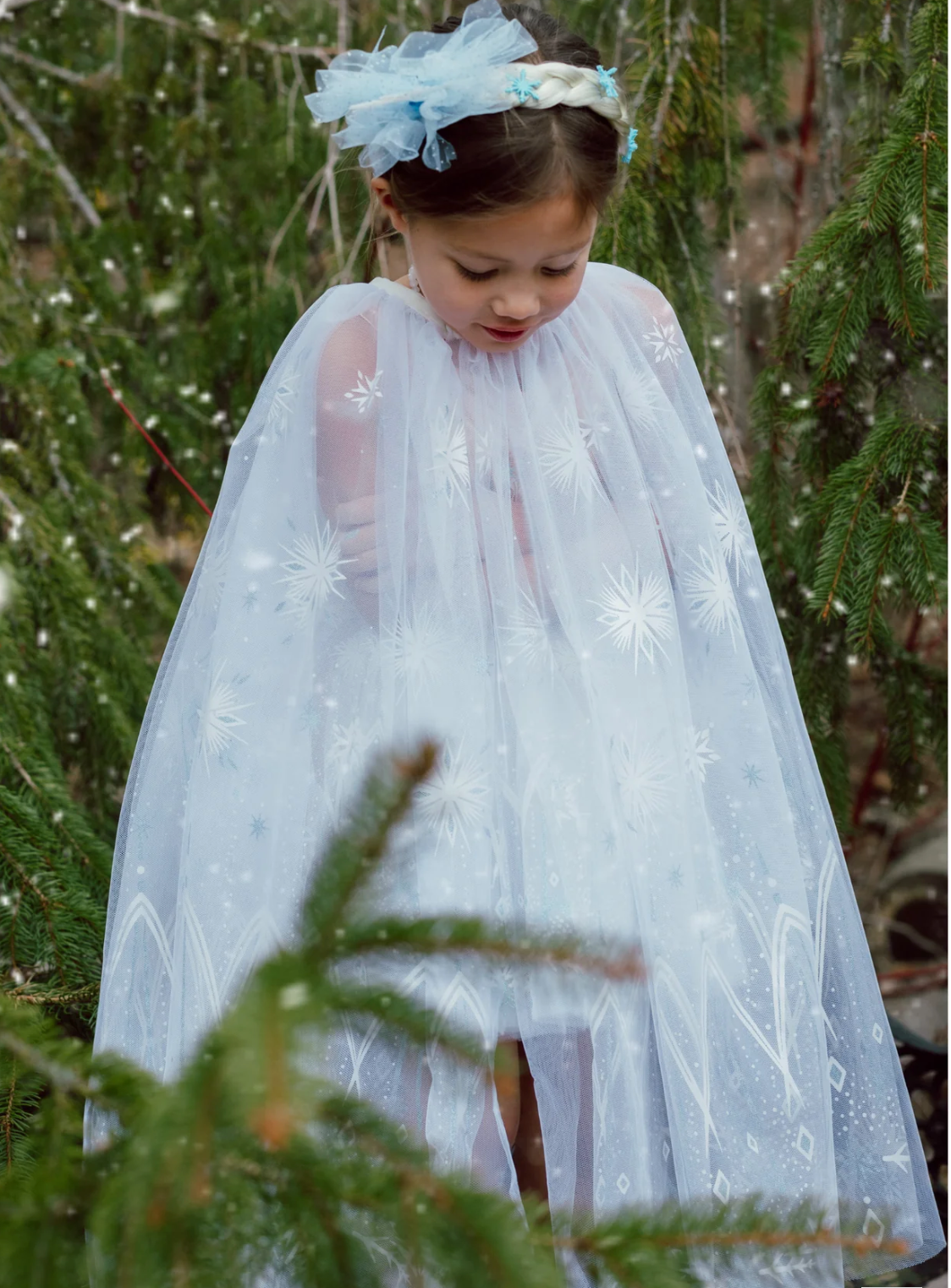 Winter Wonderland Cape | Size 5-6 worn by girl, white tulle with icy snowflake print draping gracefully outdoors.