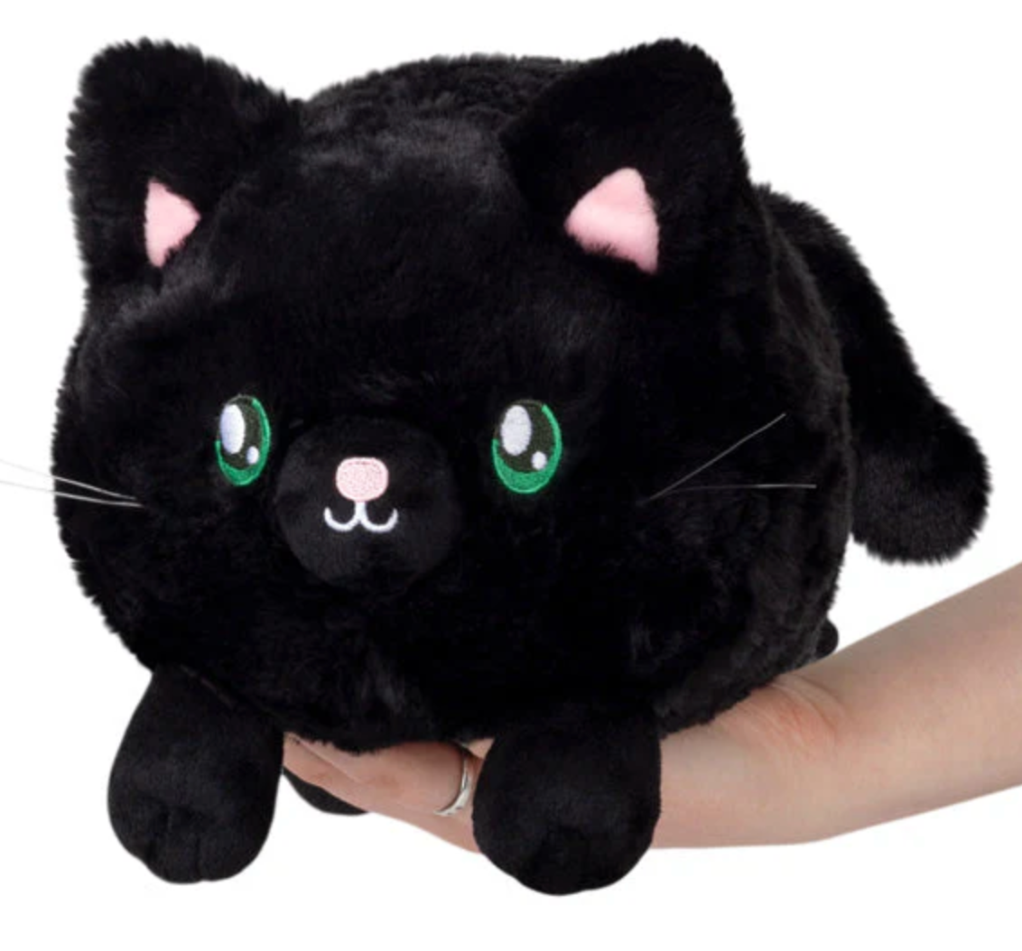 Black Kitty Mini plush with soft black fur and green eyes, perfect for cuddles and play, held in a hand.