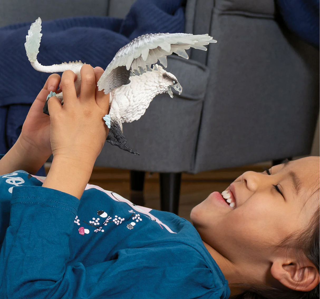 Child playing with an Ice Griffin toy featuring sharp claws, ice feathers, and a fierce beak in a friendly imaginative duel.