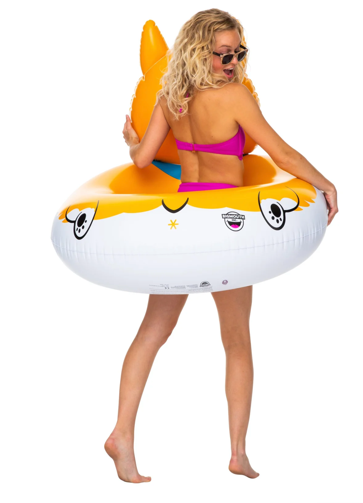 Woman in pink bikini holding a Giant Corgi Pool Float, playful and perfect for pool or beach lounging.