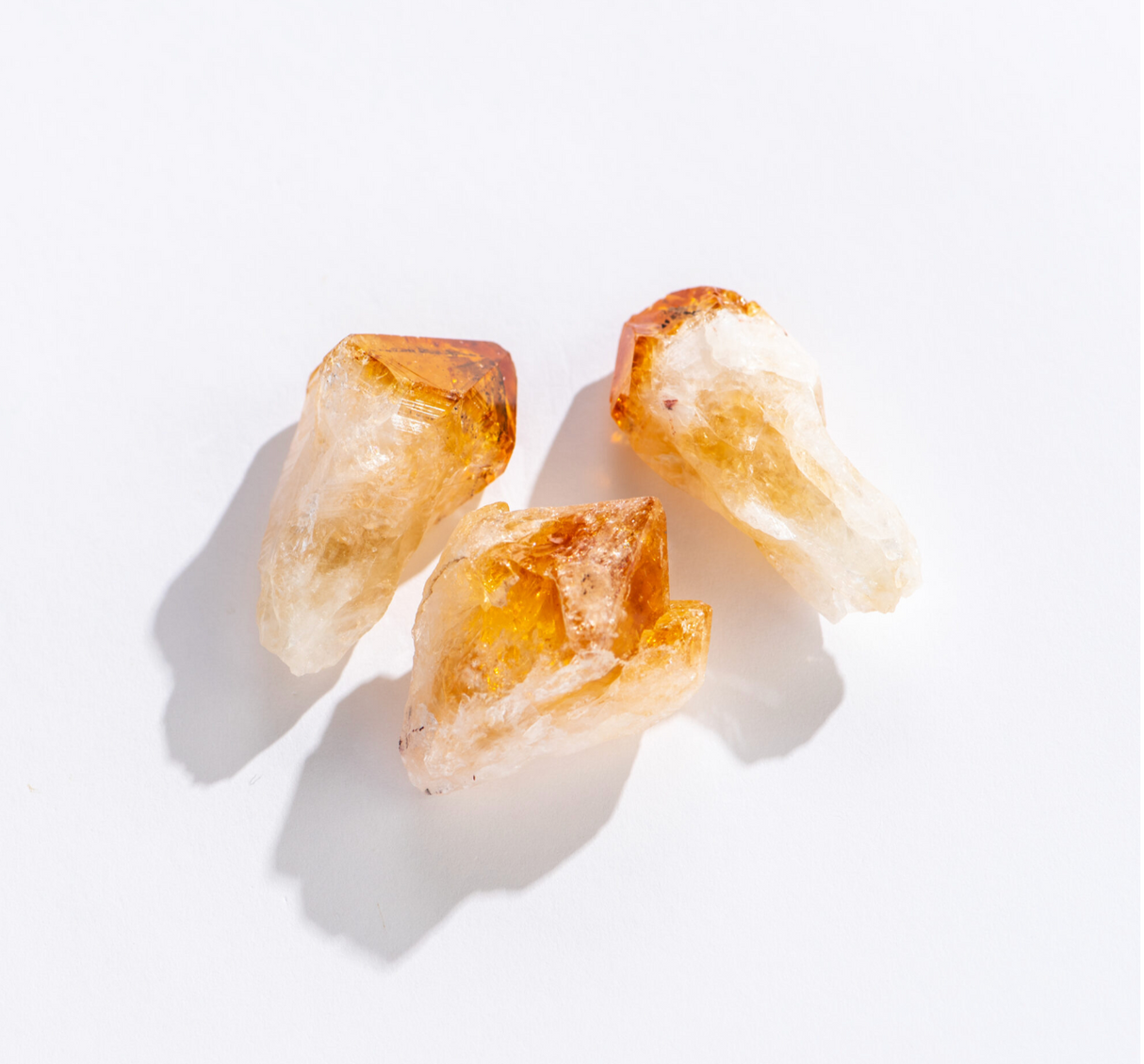 Three natural Rock | Citrine Point crystals with warm golden hues and clear quartz tips on a white background.
