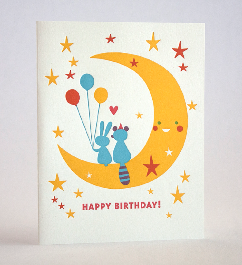 Moon Birthday Card featuring a smiling crescent moon with animals and balloons on recycled paper.