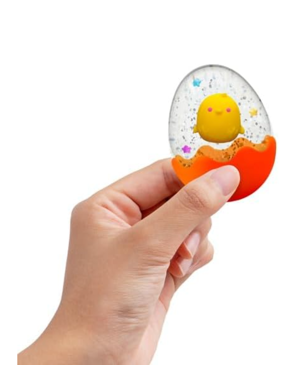 Hand holding the NeeDoh Squeezter Egg with yellow chick, confetti, and glitter inside a cracked orange shell.
