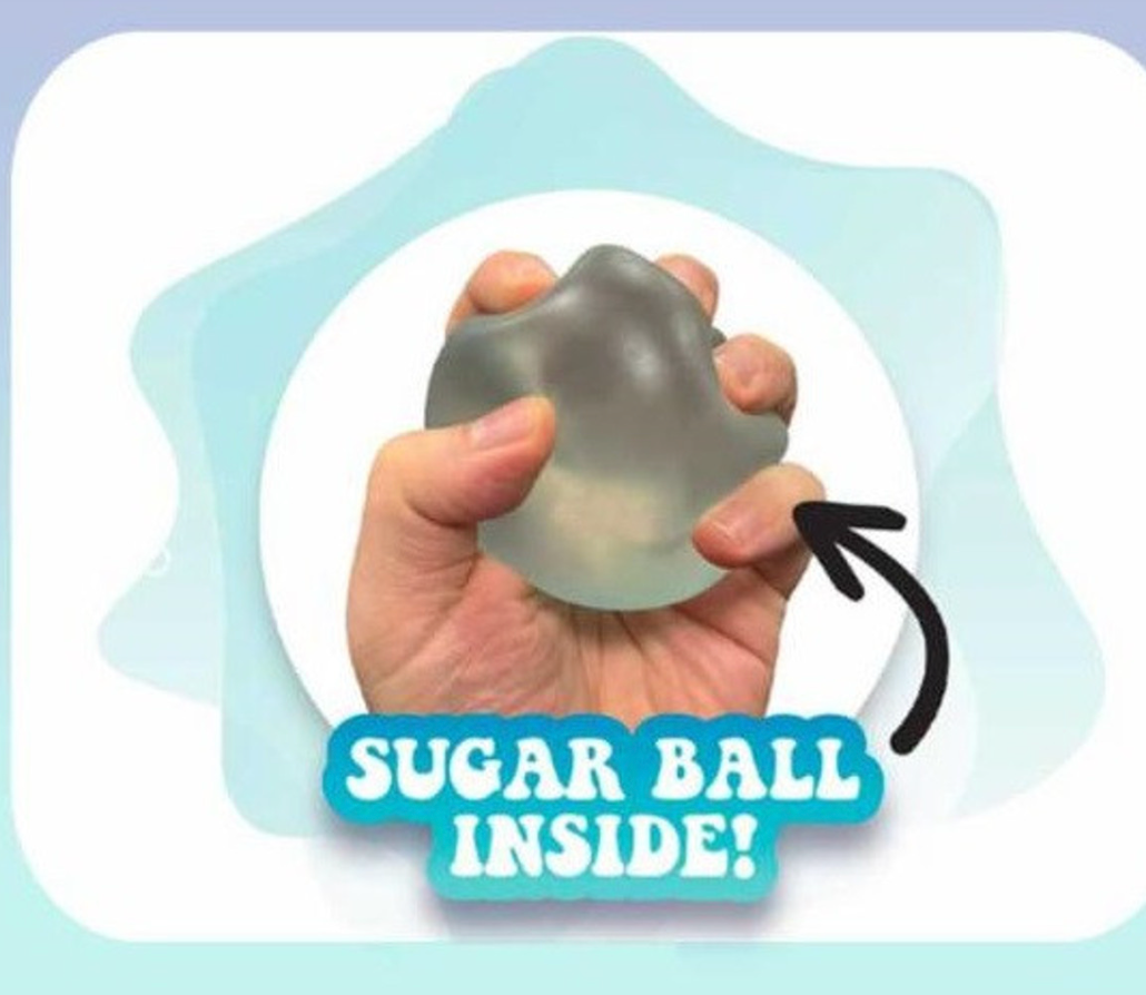 Hand squeezing clear squishy ball showing sensory core inside Sugar Squisher Plush All Stars Edition toy.