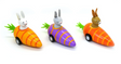 Three colorful Pull Back Bunny in Carrot Car wooden toys in orange and purple, each with a bunny ready to race.